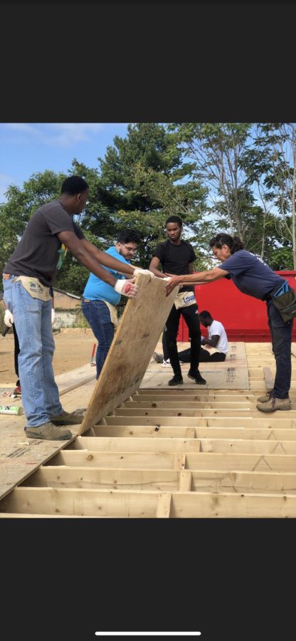 Members of MEN put in flooring for a house they helped build for Habitat for Humanity on Sept. 28, 2019. 