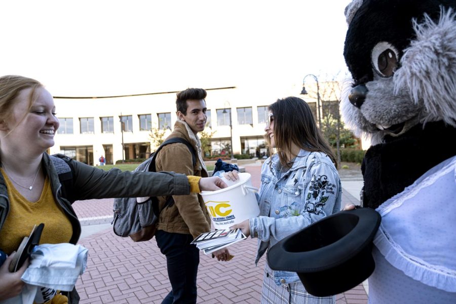 Junior visual communication design major Sarita Kumde and freshman architecture major Adryan Reyes (wearing the Condom Fairy costume) give free condoms to junior speech pathology major Breanna Lokken and sophomore early childhood education major Nick Miller during Kent Interhall Councils Condoms of the K at Risman Plaza on Monday, Oct. 21, 2019. 