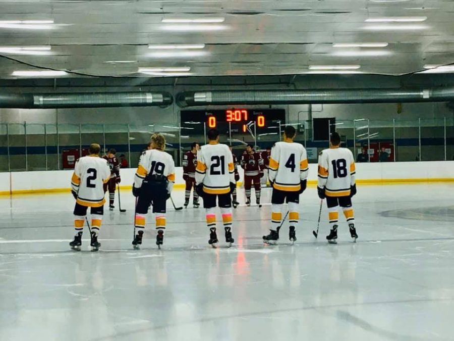 Danny Mikol stands with his teammates at center ice in the Kent State ice arena. 