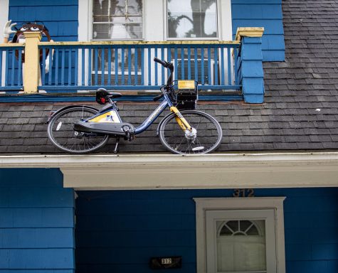 A VeoRide bike rests atop the roof of a home on S. Willow Street in Kent on Sunday, Sept. 29, 2019.