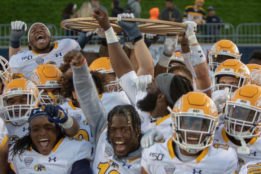 The Flashes celebrate and raise the Wagon Wheel after a 26-3 win against the Zips in Akron.
