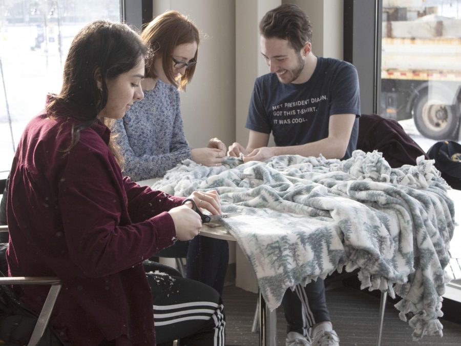 (From left to right) Senior sports administration major Angelina Denetriade, senior english major Elizabeth Laubert and senior fashion merchandising major Austin Hoepf make blankets for the MLK Day of Service on Jan. 20. 2020. The blankets were made for those experiencing homelessness.