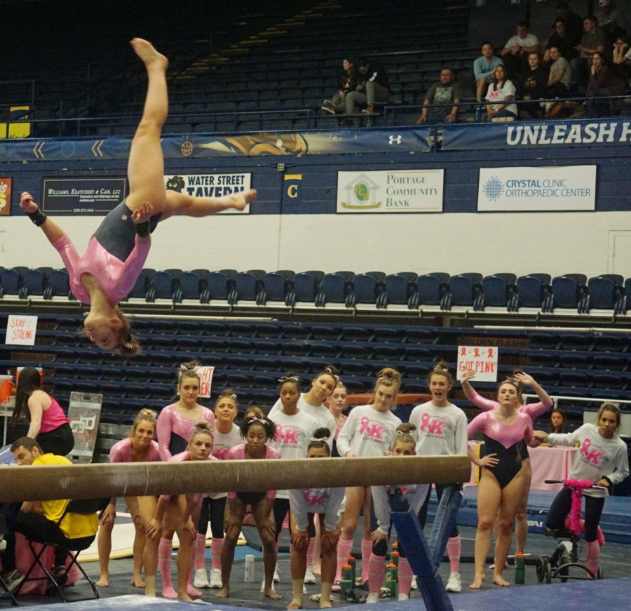 Freshman Rachel DeCavitch flips in the air on the balance beam during the annual pink meet against Bowling Green, the College at Rockport, and Ursinus College. Kent State won the meet posting its second-highest score of the season at 195.450.
