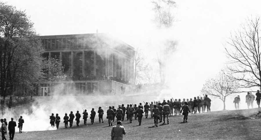 Members of the Ohio National Guard walk through a cloud of tear gas toward students and protesters near Taylor Hall at Kent State University on May 4, 1970. Courtesy of Kent State University Libraries, Special Collections and Archives.