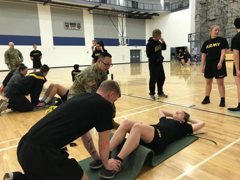 Amanda Keiser, Senior and MS4 in ROTC, does the sit-ups portion of the final senior test with Isaac Zeigler holding her feet down for support. 