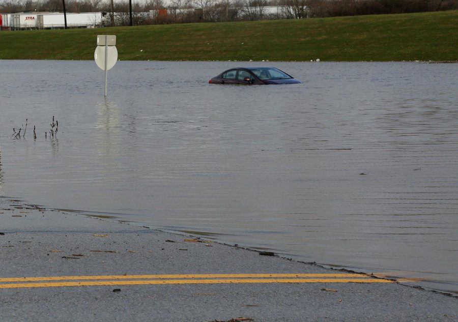 A car is submerged in the eastbound lane of Frank Road west of I-71 on Friday, March 20, 2020, in Galloway, Ohio. Thousands of people remain without power after severe thunderstorms roared through Ohio, causing flooding and knocking down trees across the state. The storms that struck late Thursday and early Friday contained heavy rains and strong, gusty winds. (Eric Albrecht/The Columbus Dispatch via AP)