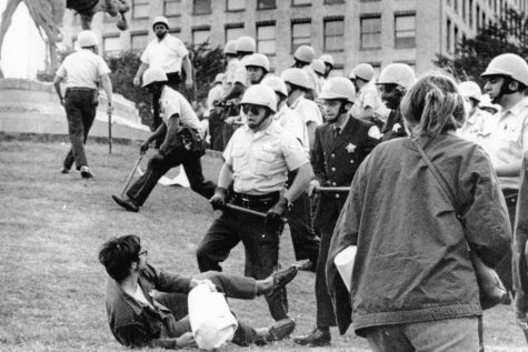 FILE - In this Aug. 26, 1968 file photo, Chicago police officers wielding nightsticks confront a demonstrator on the ground in Grant Park after protesters against the Vietnam War climbed on the statue of Civil War Gen. John Logan. It was one of many protests during the tumultuous 1968 Democratic National Convention. (AP Photo)