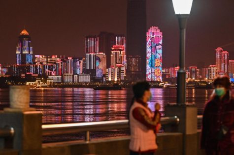 People stand near the Yangtze River in the city of Wuhan, on April 6. In recent weeks, officials have gradually eased some of the lockdown measures, allowing a limited number of residents to leave their residential compounds for a short time.