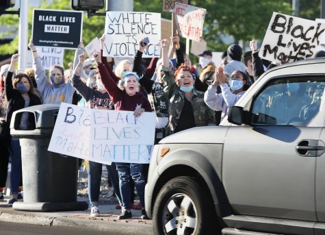 Protesters who came out for a rally to raise awareness about police brutality at Akron’s Hardesty Park stand at the corner of West Market Street and North Hawkins Avenue and yell at cars as they drive by. The event was organized in response to George Floyd’s death at the hands of Minneapolis police.