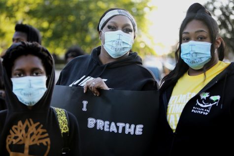 (L to R) Geonte Sandel-Clemis, Kristian Sandel and Kavie Hilton wear face masks that say “I Can’t Breathe” during a rally to raise awareness about police brutality at Akron’s Hardesty Park. The event was organized in response to George Floyd’s death at the hands of Minneapolis police.