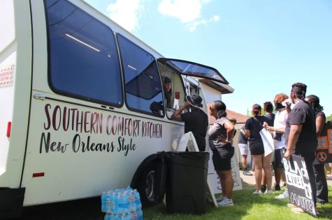 Protesters line up to purchase food at Southern Comfort Kitchen, a food truck founded by Kent State alum Will Matthews that serves New Orleans-style cuisine. The truck was parked in front of the Kent ReStore on South Water Street.