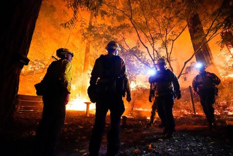 Firefighters make a stand in the backyard of a home in front of the advancing CZU August Lightning Complex Fire on Friday, Aug. 21, in Boulder Creek, California.