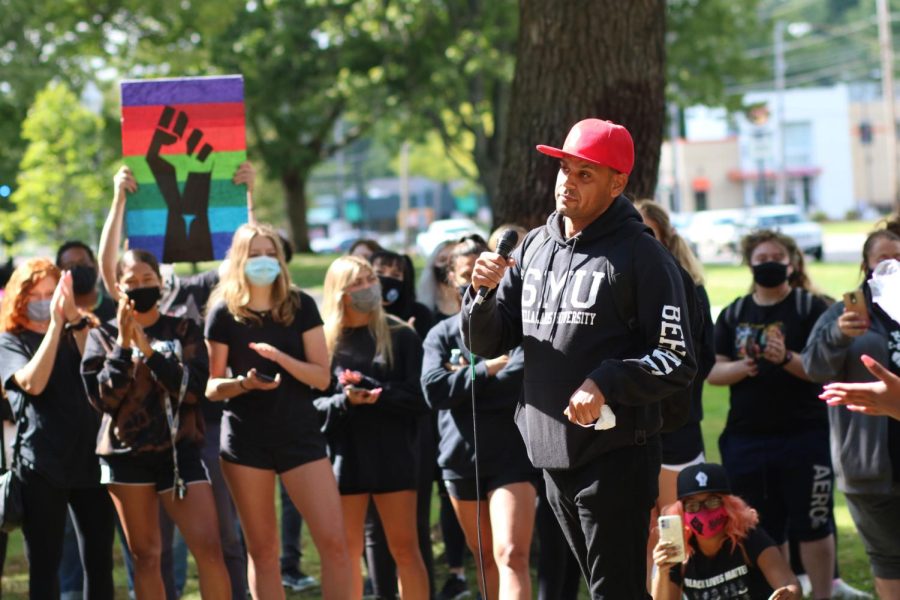 Tony Correa speaks about a LGBTQ+ sober home while a protester holds up a gay pride and Black Lives Matter sign in the background on Friday, Sep. 11.