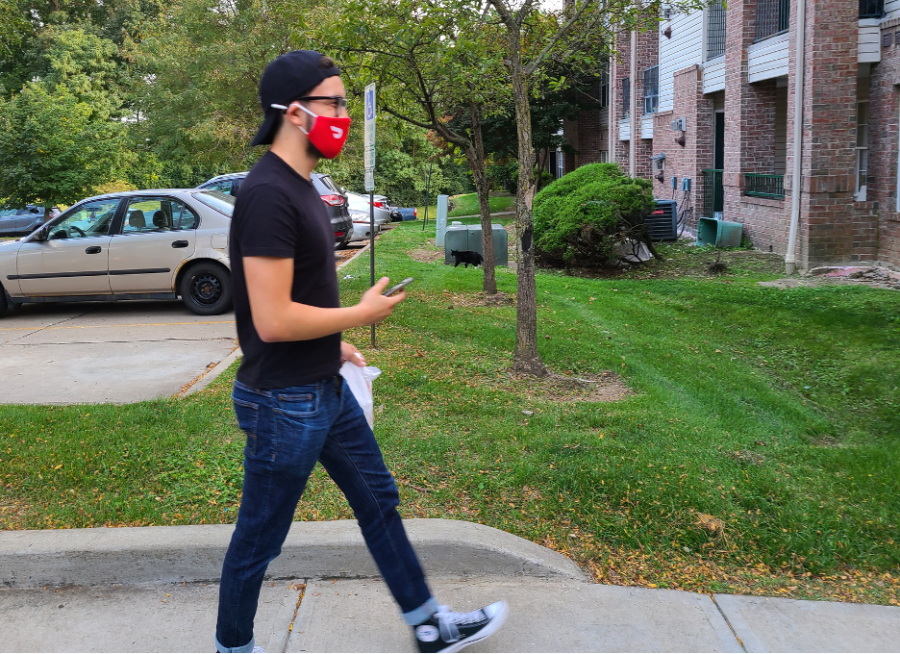 DoorDash driver Brandon Mendez, a senior finance major at Kent State, drops off a no-contact order on Sept. 17, 2020. He places the order in front of the customer’s door, takes a picture of the delivered food, knocks on the door and walks back to his car ready to complete the next order.