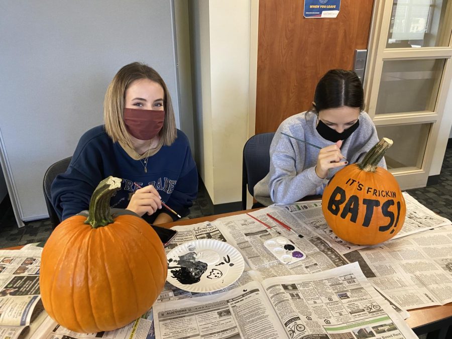 Students painting pumpkins during an Honors College pumpkin decorating event.