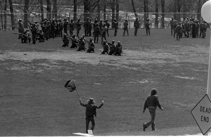 Kent State student Alan Canfora waves a flag at National Guardsmen on a practice field near Prentice Hall on the Kent State campus, May 4, 1970. Moments later, after the Guardsmen went back up Blanket Hill, they turned and fired on students and protesters, killing four students and wounding Canfora and eight others.