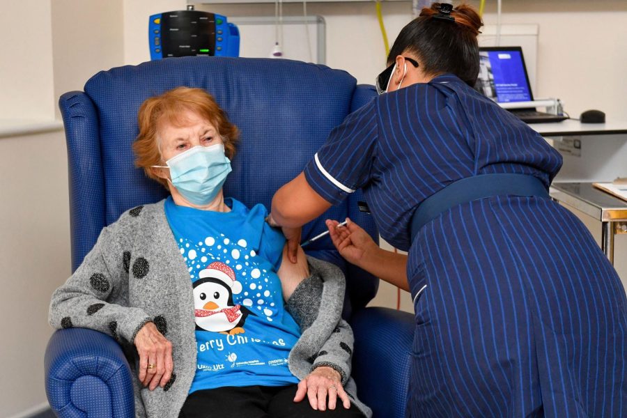 90 year old Margaret Keenan, the first patient in the UK to receive the Pfizer-BioNTech COVID-19 vaccine, administered by nurse May Parsons at University Hospital, Coventry, England, Tuesday Dec. 8, 2020. The United Kingdom, one of the countries hardest hit by the coronavirus, is beginning its vaccination campaign, a key step toward eventually ending the pandemic. 