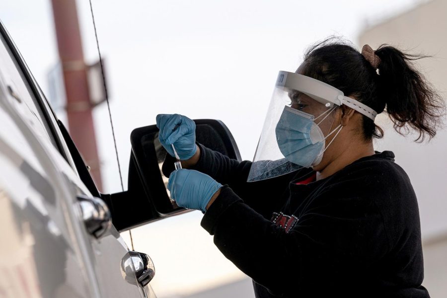 A healthcare worker wearing personal protective equipment (PPE) places a Covid-19 swab test into a vial at a United Airlines testing sire inside San Francisco International Airport (SFO) in San Francisco, California, U.S., on Thursday, Jan. 9, 2021. California reported 459 daily virus deaths, the second-highest tally since the pandemic began, as the most-populous state continues to battle a surge of cases that has strained health-care facilities. Photographer: David Paul Morris/Bloomberg via Getty Images