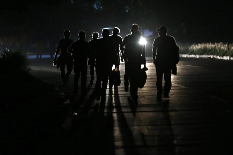 SAN PEDRO SULA, HONDURAS - JANUARY 15: The silhouette of Honduran migrants as they walk at 4:30 a.m. towards the Guatemalan border on January 15, 2021 in San Pedro Sula, Honduras. The caravan plans to walk across Guatemala and Mexico to eventually reach the United States. Central Americans expect to receive asylum and most Hondurans decided to migrate after being hit by recent hurricanes Eta and Iota. Honduras recently asked to U.S. to extend their Temporary Protected Status. (Photo by Milo Espinoza/Getty Images)