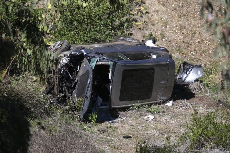 A vehicle rests on its side after a rollover accident involving golfer Tiger Woods along a road in the Rancho Palos Verdes section of Los Angeles on Tuesday, Feb. 23, 2021. Woods suffered leg injuries in the one-car accident and was undergoing surgery, authorities and his manager said. (AP Photo/Ringo H.W. Chiu)