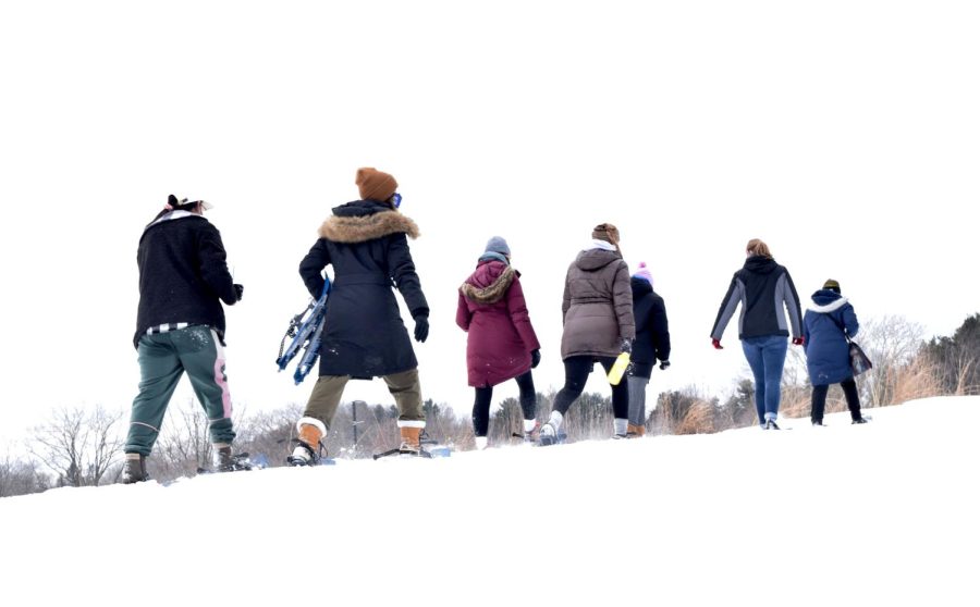 A group of students and student workers walk around the Recreation and Wellness Center on a snowshoe hike on Feb. 17, 2021.