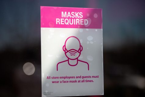 AUSTIN, TX - MARCH 03: A Covid-19 restriction sign hangs inside a T-Mobile store on March 3, 2021 in Austin, Texas. Gov. Greg Abbott announced today that the state will end its mask mandate and allow businesses to reopen at 100 percent capacity on March 10. (Photo by Montinique Monroe/Getty Images)