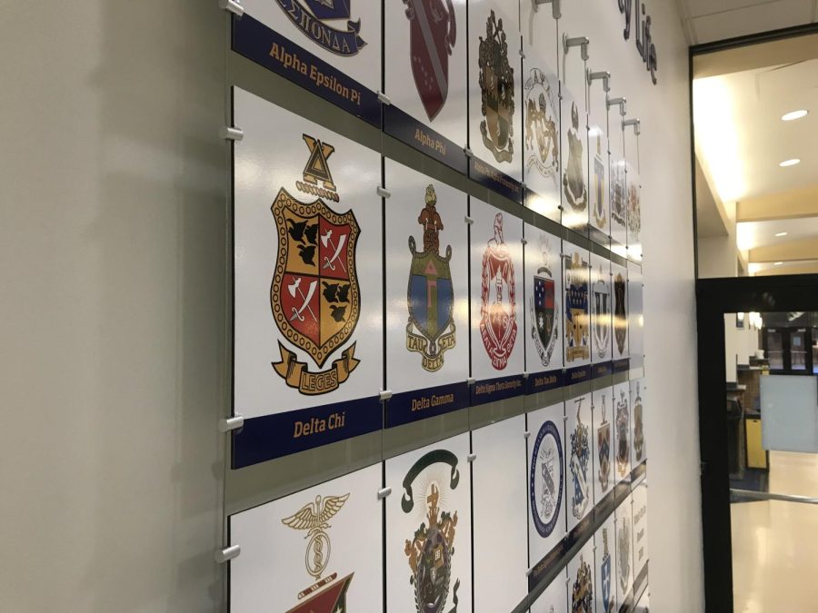 The crests of several Greek life organizations on a wall near the dining hall known as the Hub in the Kent Student Center. Collins anti-hazing law in Ohio will criminalize hazing by any organizations, including campus Greek life.