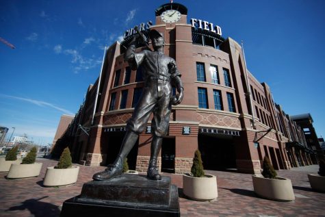 A scuplture entitled The Player by George Lundeen stands outside the main entracne to Coors Field, home of Major League Baseballs Colorado Rockies, as the sidewalks stand empty on the leagues scheduled opening day for the 2020 season with a statewide stay-at-home order taking effect to reduce the spread of the new coronavirus Thursday, March 26, 2020, in Denver. The new coronavirus causes mild or moderate symptoms for most people, but for some, especially older adults and people with existing health problems, it can cause more severe illness or death. (AP Photo/David Zalubowski)