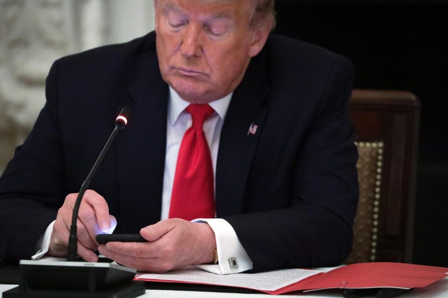 U.S. President Donald Trump works on his phone during a roundtable at the State Dining Room of the White House June 18, 2020 in Washington, DC. President Trump held a roundtable discussion with Governors and small business owners on the reopening of American’s small business.