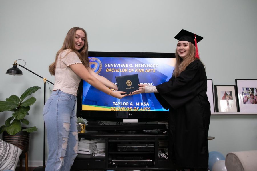 Genevieve Menyhart (right) poses in her cap and gown as she graduates from her living room with a Bachelor of Fine Arts in Photography in May 2020. Menyhart is a wedding photographer and is hopeful for the future of wedding photography this summer.
