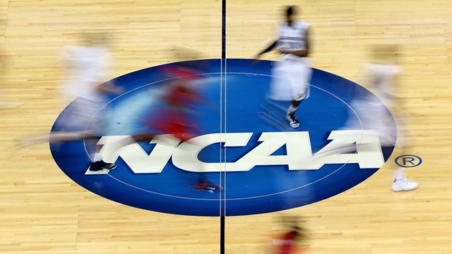 Mississippi Rebels and Xavier Musketeers players run by the NCAA logo at mid-court.