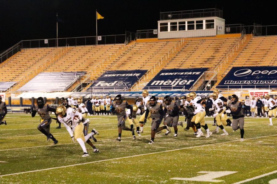 Kent and Akron football players run down the field at Dix Stadium on Tuesday, Nov. 17. Photo by Morgan McGrath.