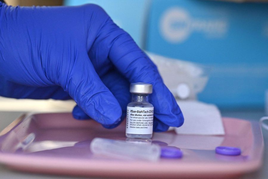 A nurse reaches for a vial of Pfizer-BioNTech Covid-19 vaccine at a pop up vaccine clinic in the Arleta neighborhood of Los Angeles, California, August 23, 2021. - The US Food and Drug Administration on August 23, fully approved the Pfizer-BioNTech Covid shot, triggering a new wave of vaccine mandates as the Delta variant batters the country. Around 52 percent of the American population is fully vaccinated, but health authorities have hit a wall of vaccine hesitant people, impeding the national campaign. (Photo by Robyn Beck / AFP) (Photo by ROBYN BECK/AFP via Getty Images)
