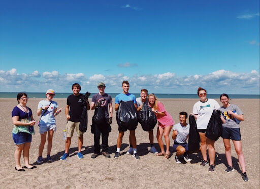 Members of Ocean Motion smile at the shore after their 2020 beach clean up.