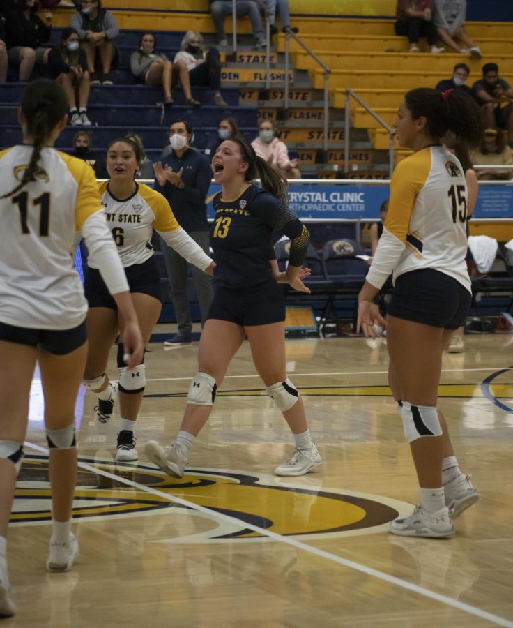 Senior defensive specialist Erin Gardner (13) celebrates getting a point with her teammates during the volleyball game on Oct. 8, 2021. The Flashes lost to Central Michigan University 3-1.