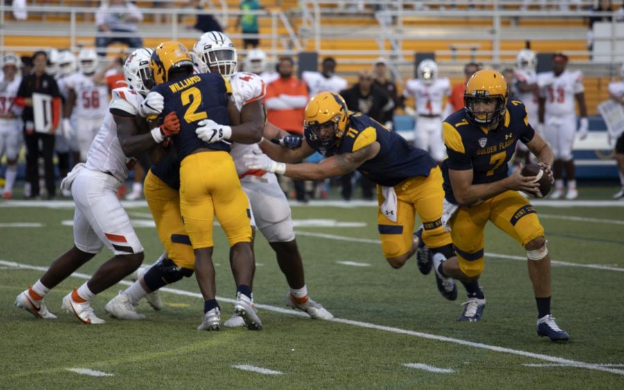 Grad student Dustin Crum, number 7, runs with the ball and scores a touchdown during the football game against Bowling Green State University on Oct. 2, 2021. The Golden Flashes won their homecoming game 27-20.
