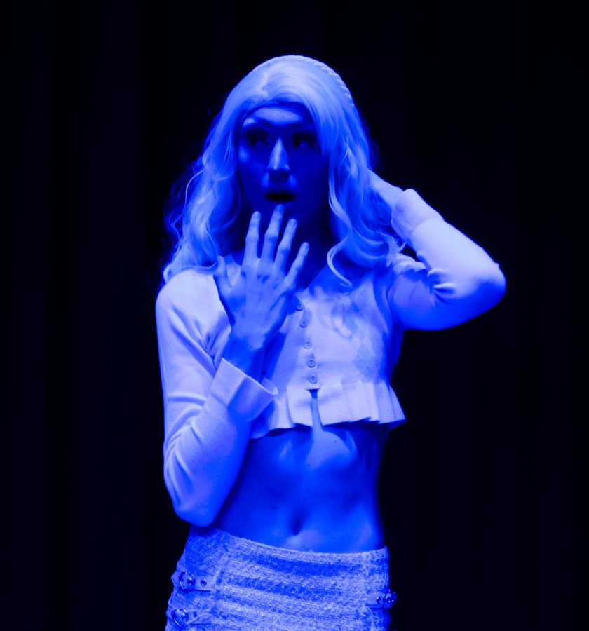 Trevor, known as Theta Lite, poses in the blue light on the stage before the Sex Week Drag Show on Oct. 20, 2021. 