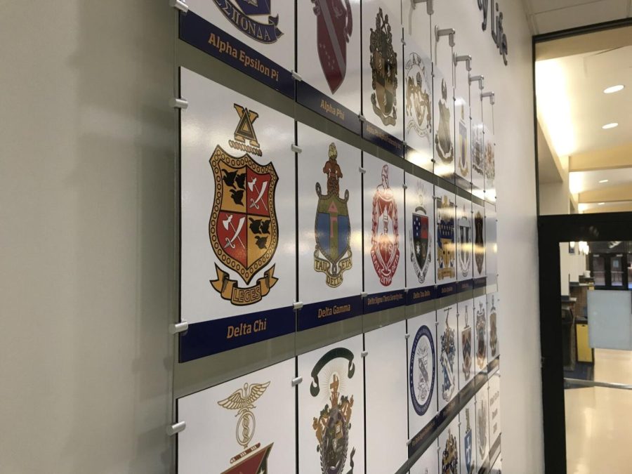 The crests of several Greek life organizations on a wall near the dining hall known as the Hub in the Kent Student Center. Ohios Collins Law, which went into effect Thursday, criminalizes hazing by any organizations, including on-campus Greek life.