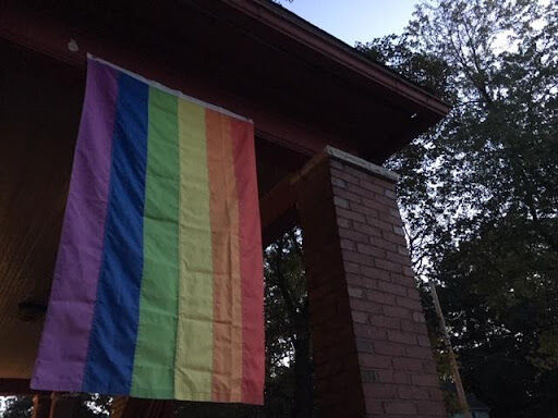 LGBTQ flag hanging from a porch.