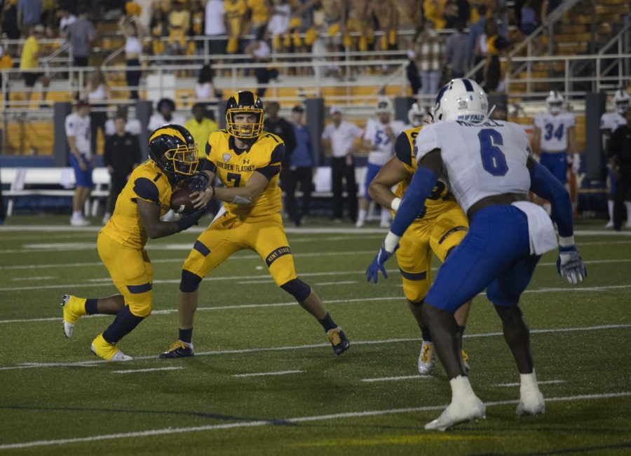Quarterback Dustin Crum (7) hands the ball off to running back Marquez Cooper (1) during the football game against University of Buffalo on Oct. 9, 2021. Kent State beat Univeristy of Buffalo 48-38.