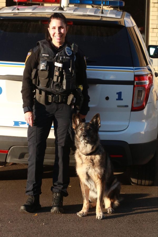 Officer Anne Spahr, the Explosion Detective K9 Handler for Kent State Police, poses outside of Stockdale Hall with her K9, Coco.