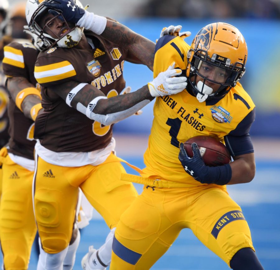 Kent States Marquez Cooper pushes off against a Wisconsin defender during first half action at the Famous Idaho Potato Bowl in Boise, Idaho. Kent State lost the game 52-38. Photo by Bob Christy/Courtesy of Kent State University