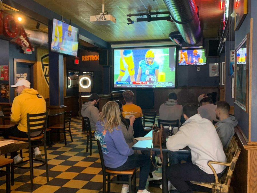 Kent State football fans sat in front of Water Street Tavern’s big screen to watch the beginning of the first quarter of the 2021 MAC Championship game against Northern Illinois University on Saturday, Dec. 04, 2021. 