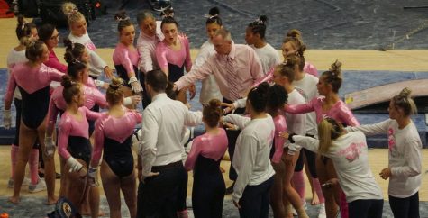 The Kent State gymnastics team huddles up before going on the uneven parallel bars at the annual pink meet against Bowling Green, the College at Rockport, and Ursinus College at the M.A.C.C. on Friday, Feb. 28, 2020. Kent State won the meet posting its second-highest score of the season with a score of 195.450.