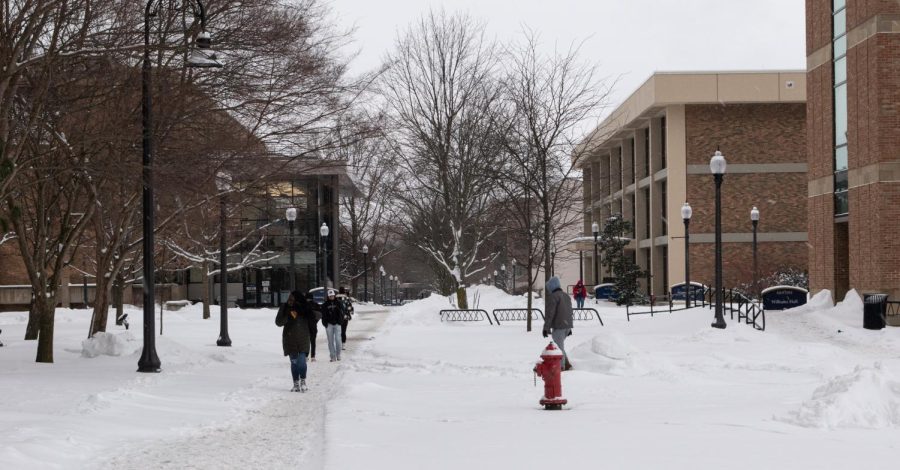 Kent State students make the trek down snow-slick sidewalks near Williams Hall on Monday, Jan. 24, 2022