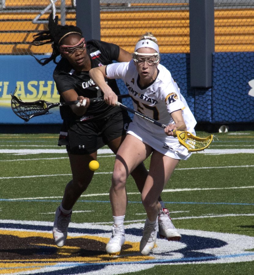 Sophomore midfielder Abby Jones [27] fights for the ball during the women’s lacrosse game on Mar. 8, 2020. Kent State University lost to University of Cincinnati 25-8. 