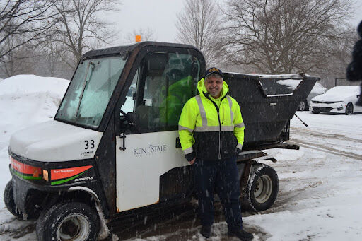 University groundskeeper Dav Roso stands next to his university vehicle on Thursday, Feb. 3, 2022. Roso began his workday at 6 a.m. to help with the snow removal process following a 22-mile commute to campus. Although the university closed Kent State campuses on Thursday, university groundskeepers and operators were on campus to get ahead of snowfall from Winter Storm Landon.