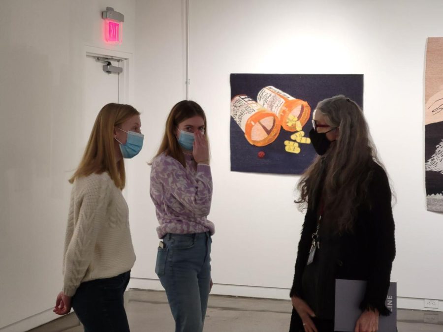 Kent State students Romy Anderson (center) and Molly Hudson (left) talk with exhibit curator Janice Lessman-Moss during the Line by Line exhibit.