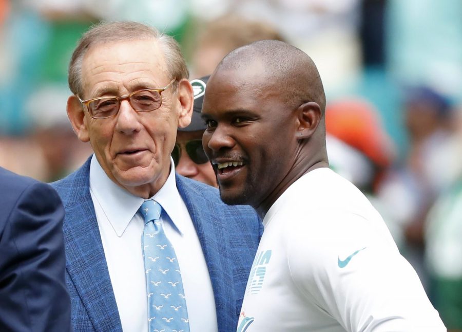 Former Miami Dolphins head coach Brian Flores talks to Miami Dolphins owner Stephen M. Ross during practice before an NFL football game against the New York Jets, Sunday, Nov. 3, 2019, in Miami Gardens, Florida. Flores sued the NFL and three of its teams Tuesday, Feb. 1, 2022 saying racist hiring practices by the league have left it racially segregated and managed like a plantation.(AP Photo/Wilfredo Lee, File)