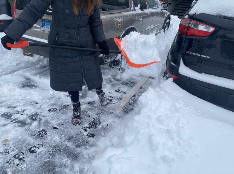 Tara McFadden shovels the parking lot on Monday, January 17, 2022, to clear snow from around the vehicles at The Province apartment complex in Kent, OH. 